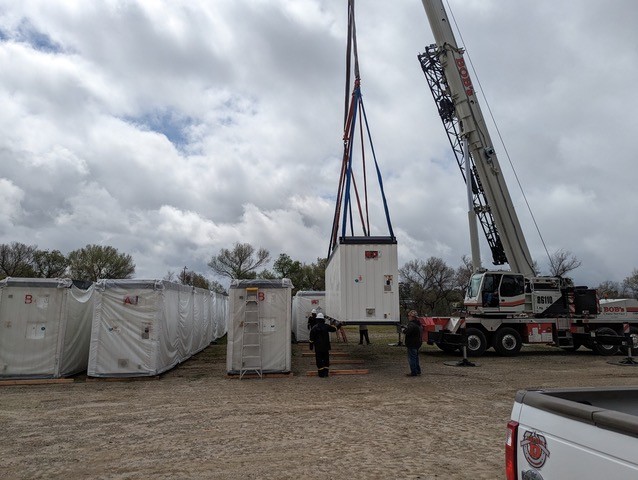 A crane lifting a containerDescription automatically generated
