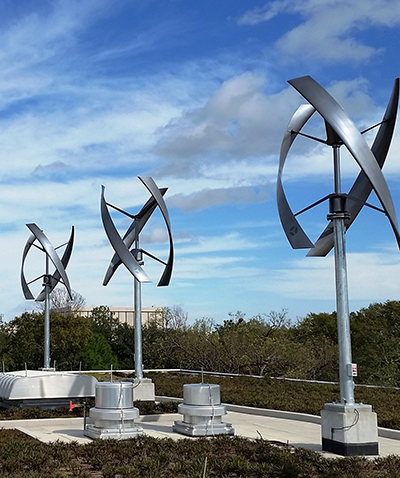 vertical wind turbines against a blue sky.